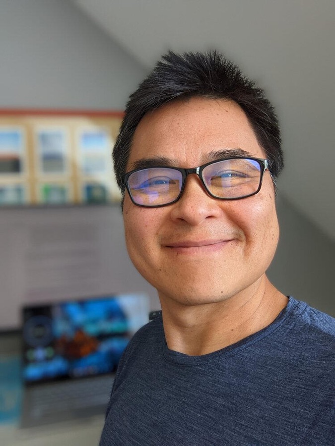 James Lau, smiling, in glasses and a grey T-shirt.